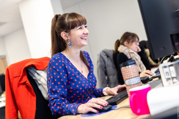 Une collaboratrice Yumens BtoB souriante à son bureau